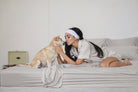 Woman kissing her dog on Misty Dove Gray bamboo sheets (colour visualisation)